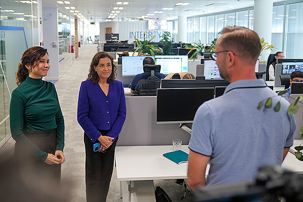 Ayuso y Sara Gómez, directora del centro de Roche Informatics Madrid, charlan con uno de los empleados de la compañía.