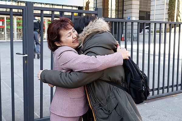 Madre e hija se abrazan a la salida del examen.