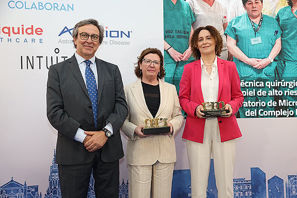 Juan López Cazorla. Director Comercial para España y Portugal de Intuitive, entrega el premio a Ángeles Flórez Menéndez. Jefa del Servicio de Dermatología del Hospital Clínico de Santiago (CHUS), y a Isabel Paz Vidal. Jefa del Servicio de Microbiología del Complejo Hospitalario de Ourense.