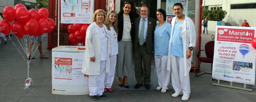 Personal sanitario del Hospital La Paz de Madrid posa con el gerente del centro, Rafael Pérez-Santamarina (con traje), en el stand del maratón.