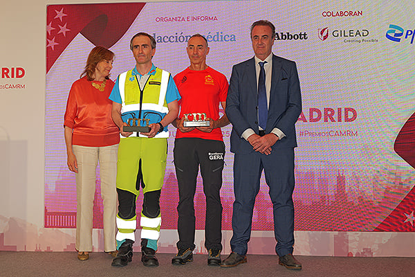 Celia García, directora General de Humanización, Atención y Seguridad del Paciente de la Consejería de Sanidad de la Comunidad de Madrid; y Víctor Pedrera, secretario General de la Confederación Española de Sindicatos Médicos (CESM), entregan el premio de la categoría de Administración Sanitaria a Mikel García Onagoitia. Subdirector de Enfermería del SUMMA 112; e Israel Yagüe Sánchez. Jefe Supervisor del GERA perteneciente al Cuerpo de Bomberos de la Comunidad de Madrid.