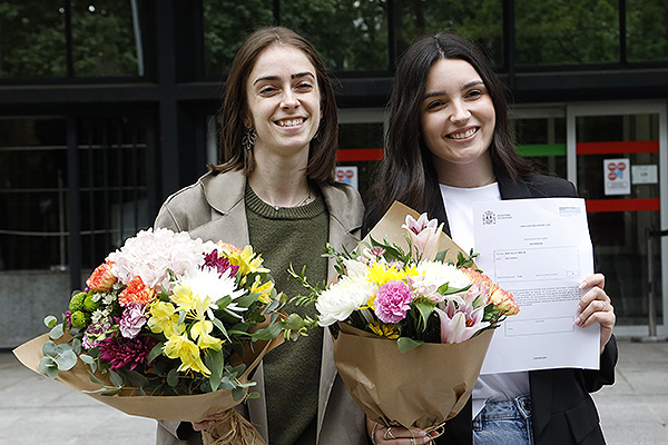 Una EIR es fotografíada junto a su plaza y su amiga.