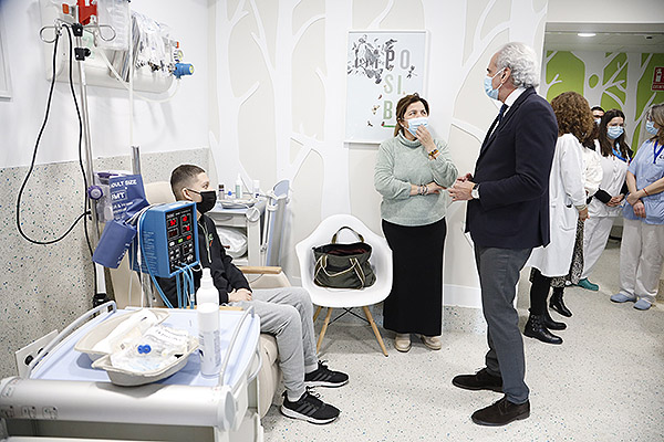 Enrique Ruiz Escudero charlando con un paciente y su madre.