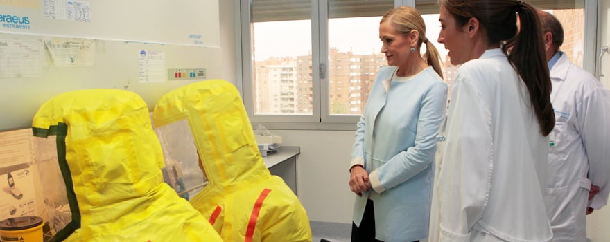 Cifuentes observa cómo trabajan dos de los profesionales sanitarios de la Unidad de Aislamiento. 