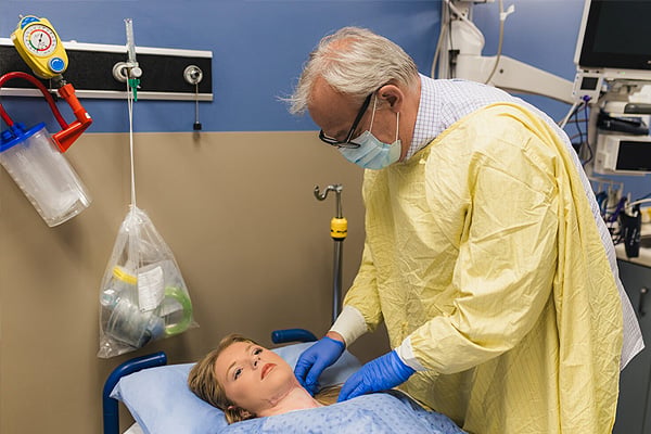 El Dr. Marc Jeschke examina el cuello de Kaitlin Jeffrey, el cual todavía presenta cicatrices activas.