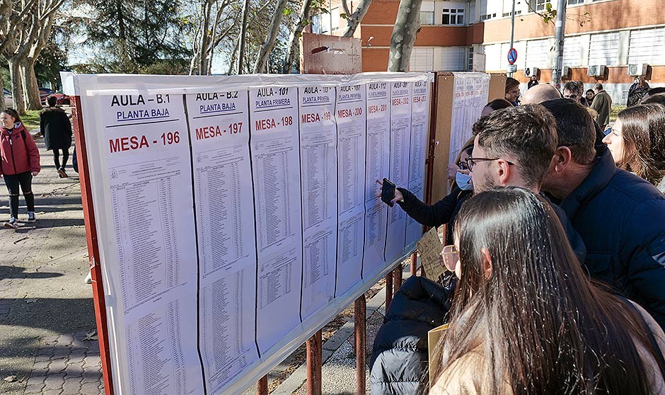 Estudiantes MIR consultado la lista en la entrada a la facultad