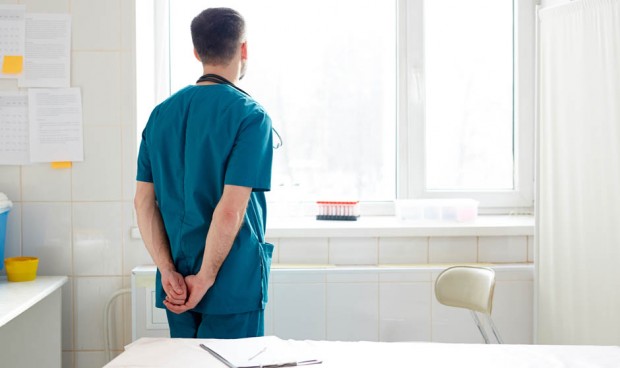 Un médico mirando por la ventana durante una guardia de 24h