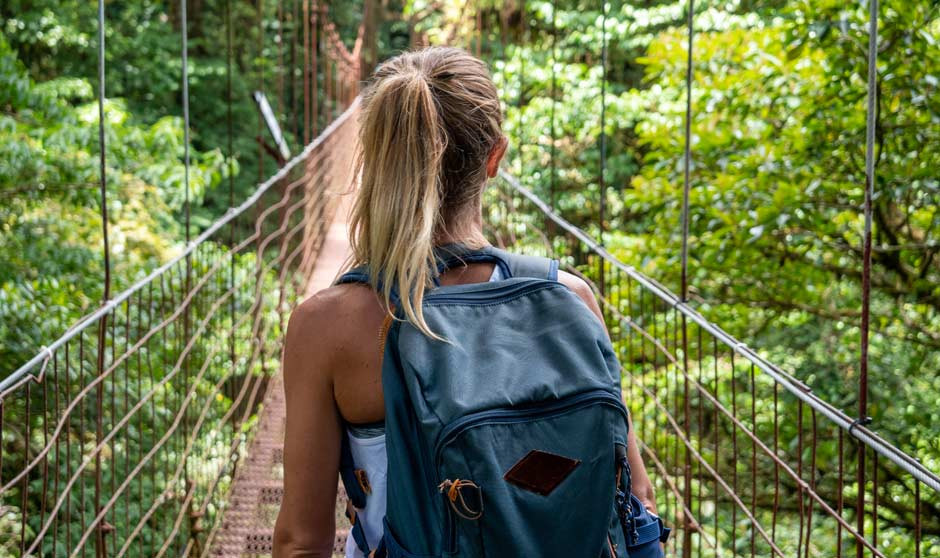 Mujer joven con mochila cruza un puente en la campaña #TuLoHacesVisible, que promueve el uso del parche anticonceptivo Evra como opción eficaz y semanal.