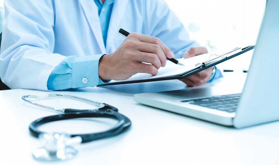 Médico revisando documentación clínica en una consulta sanitaria privada