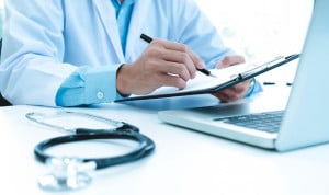 Médico revisando documentación clínica en una consulta sanitaria privada