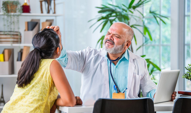 Un médico atiende a un paciente en su consulta.