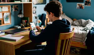 Un menor consulta las redes sociales en su habitación