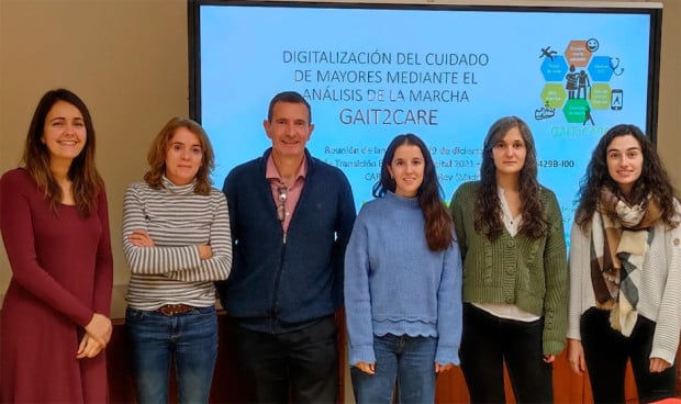 Un grupo de personas posan con una pantalla que muestra una investigación