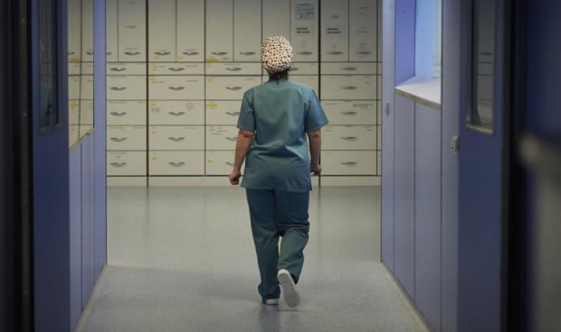Una médica anda por el pasillo de un hospital durante una guardia. 