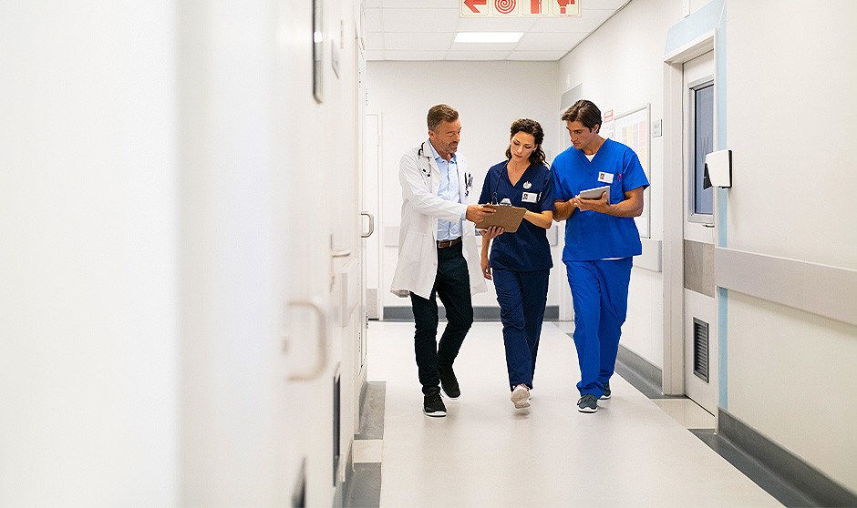Una enfermera mira un cuadrante en el pasillo de un hospital, en pleno debate sobre turnos de 12 horas. 