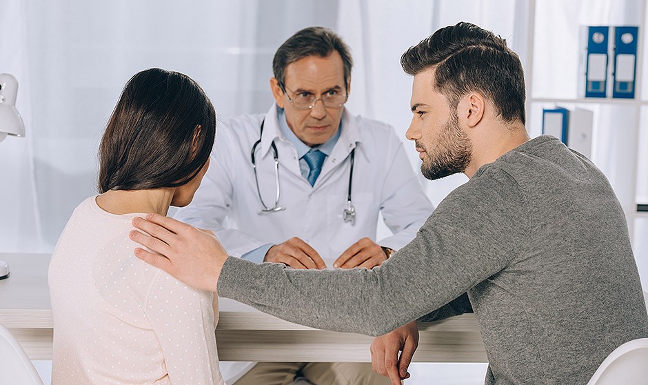 Una pareja discutiendo ante un médico