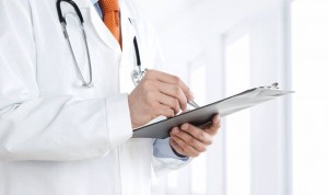 Un médico apunta datos en una libreta en el arranque de la campaña de la Renta 