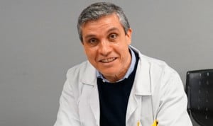 Médico posa a cámara sonriente con bata blanca