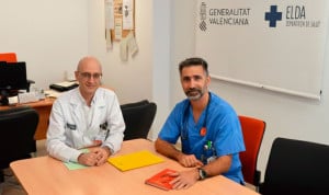 Dos médicos sentados en una mesa mirando a cámara