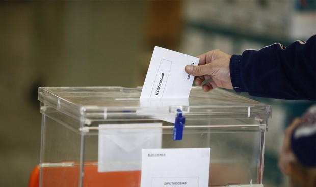 Una persona entrega su voto en la urna electoral. 
