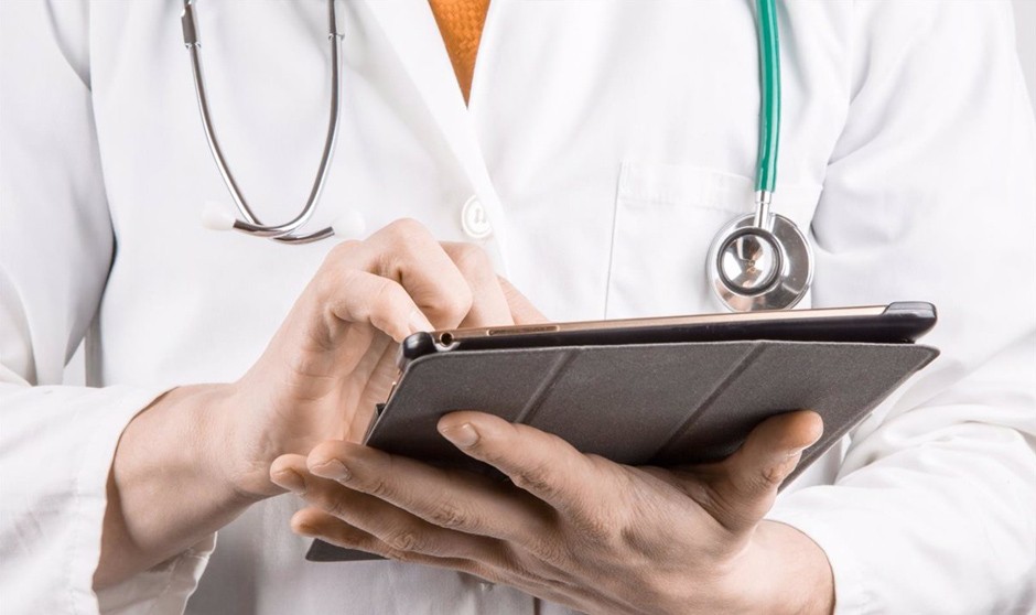 Un médico manipula su tablet en el hospital, en plena pugna por el contrato público para formar sanitarios en digitalización.