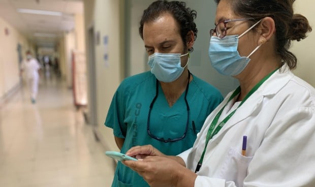  Profesionales sanitarios consultan su smartphone.