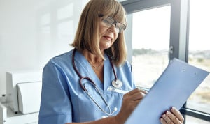 Una enfermera tomando apuntes de un paciente