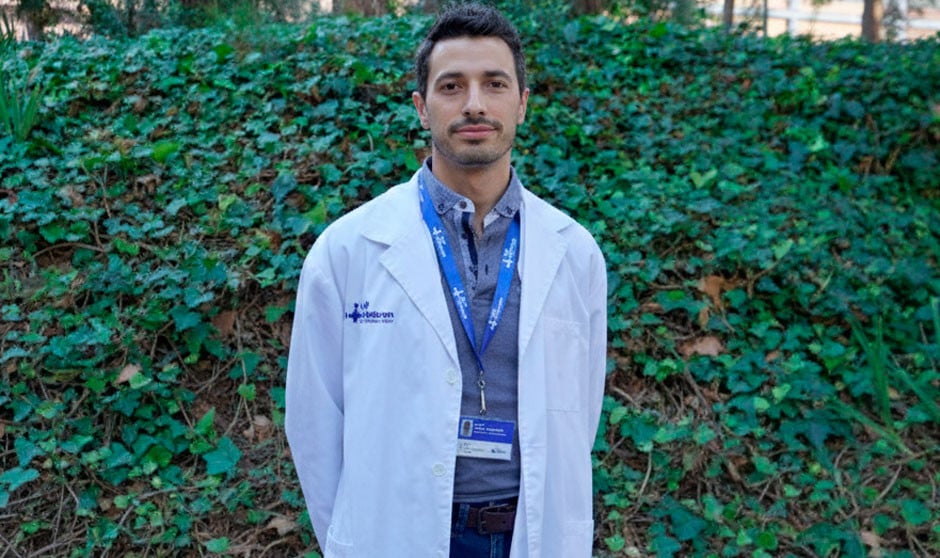 Joven médico de hospital posando con bata