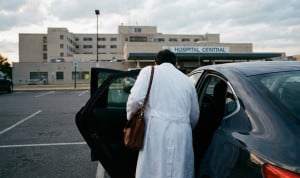 Personal sanitario ingresando a un coche para desplazarse al domicilio de un paciente.