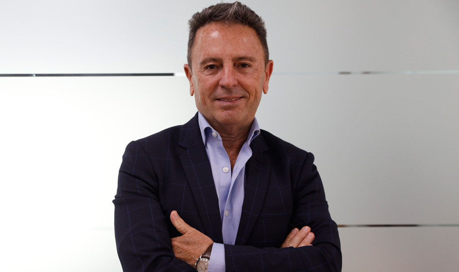 Un hombre con traje y sonriente posa ante la cámara