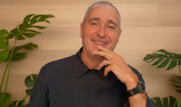 Un hombre vestido de negro sonríe a cámara