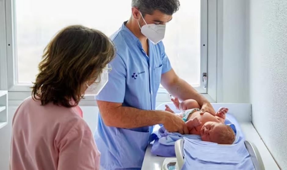 Un médico atendiendo a un bebé. 