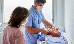 Un médico atendiendo a un bebé. 