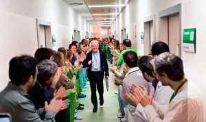 Un pasillo de hospital lleno de profesionales que aplauden a un médico senior