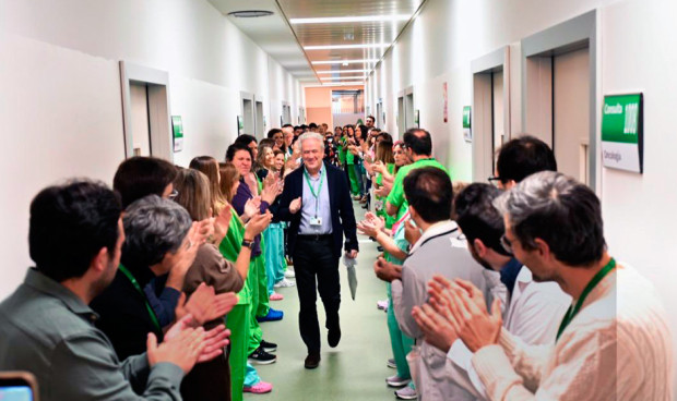 Un pasillo de hospital lleno de profesionales que aplauden a un médico senior