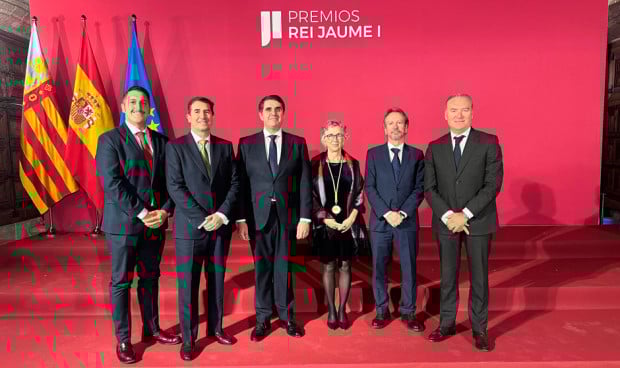 Hombres posan con una mujer premiada