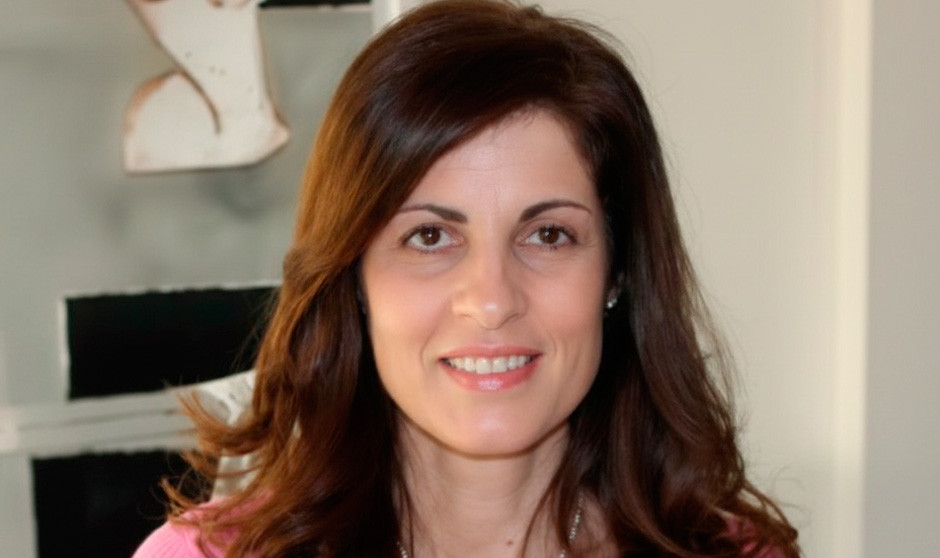 Una enfermera mira a cámara sonriente.