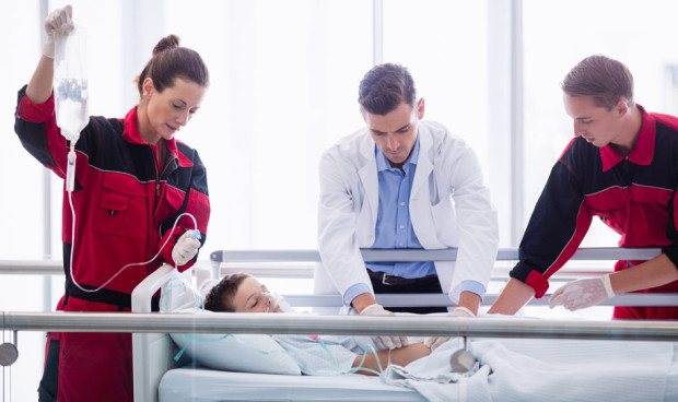 Equipo médico atiende a un paciente infantil en urgencias, simbolizando la asistencia sanitaria internacional en situaciones críticas.