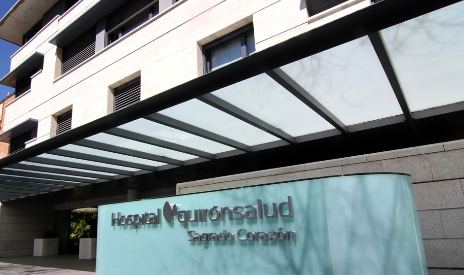 Un médico con bata posa mirando a cámara con los brazos cruzados.