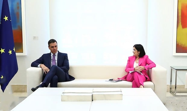 El presidente del Gobierno, Pedro Sánchez, y la ministra de Sanidad, Carolina Darias, conversan en un sillón de Moncloa. 