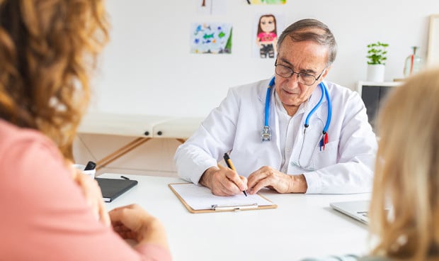 Un médico atendiendo una consulta. 